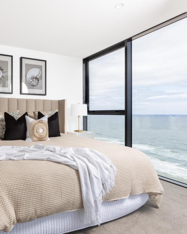 a bedroom with a large bed with a view of the ocean at Sandbar Burleigh - Official in Gold Coast