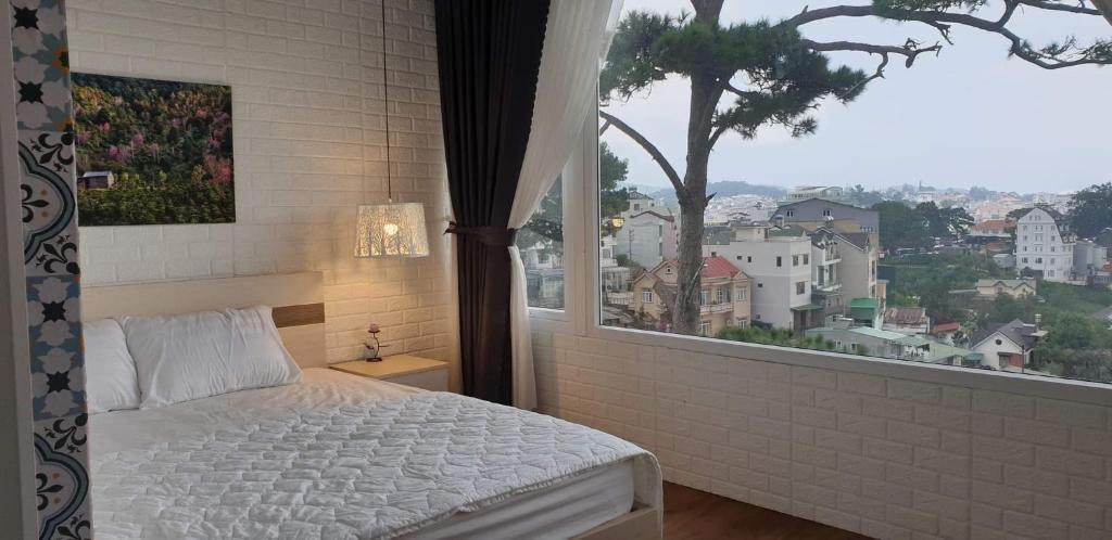 Dormitorio con ventana con cama y vistas en Bồ Công Anh hostel, en Xuan An