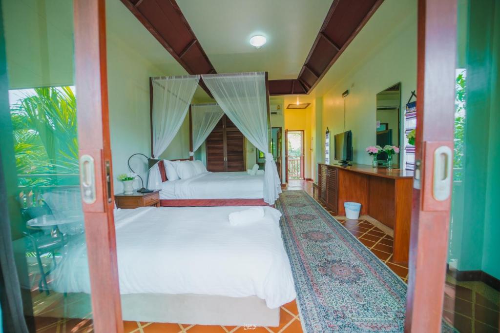 1 Schlafzimmer mit 2 Betten in einem Zimmer in der Unterkunft Siam Tara Resort Chiangkhong in Chiang Khong