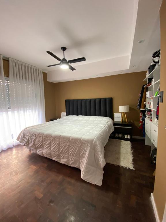 a bedroom with a large bed with a ceiling fan at HERMOSO DEPTO BIEN UBICADO in Santa Fe