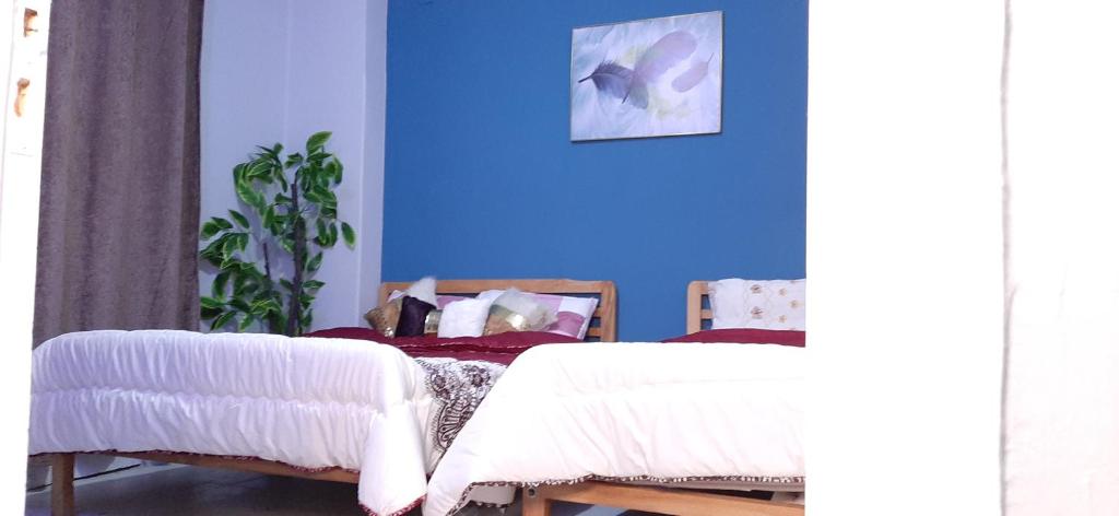 a bedroom with two beds and a blue wall at Joy Homes in Cairo