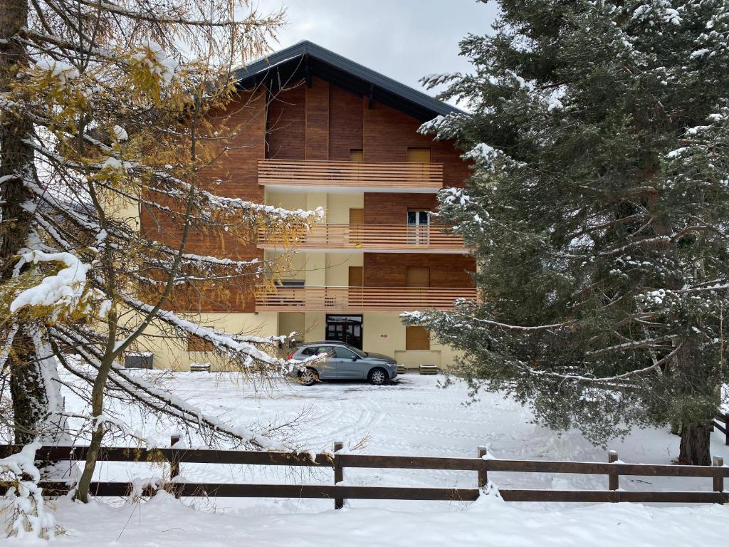 ベッラモンテにあるCasa ai Dossiの雪に停められた車を持つ家