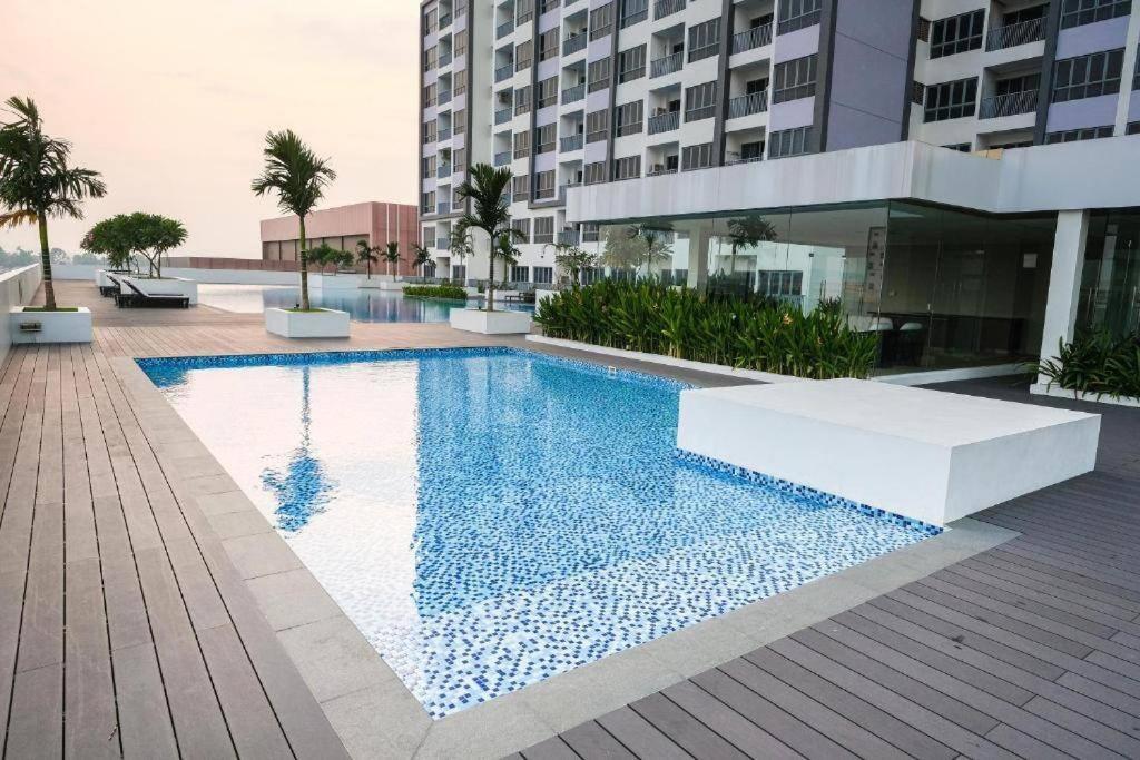 a swimming pool in front of a building at Luxury Apartment, Harbour Bay in Jodoh