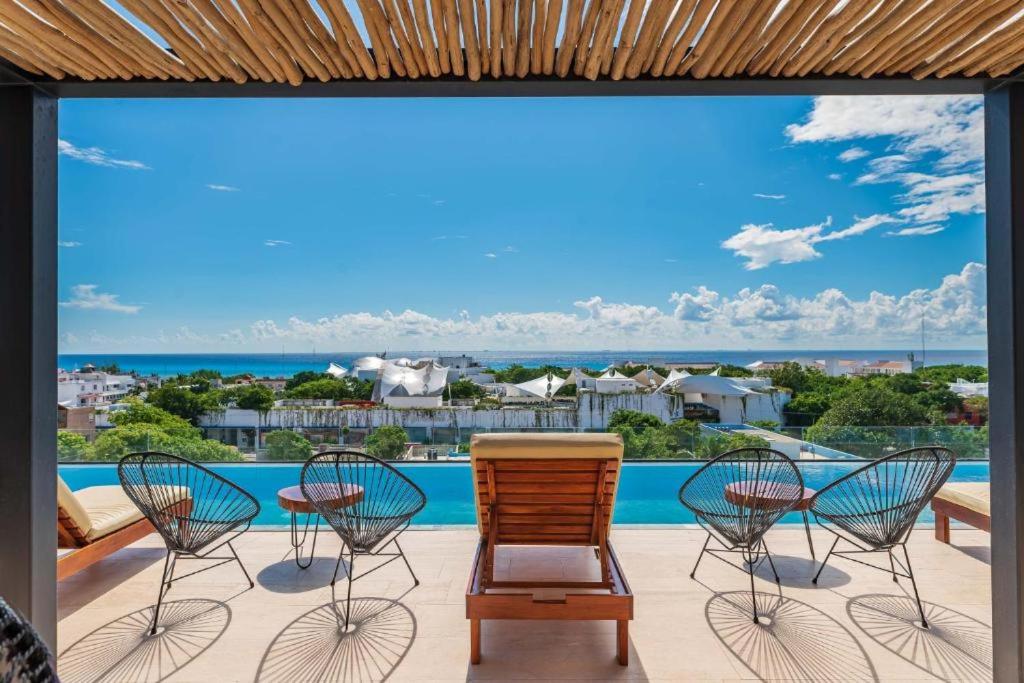 プラヤ・デル・カルメンにあるPaseo Luxury Houseの海の景色を望むパティオ(椅子付)