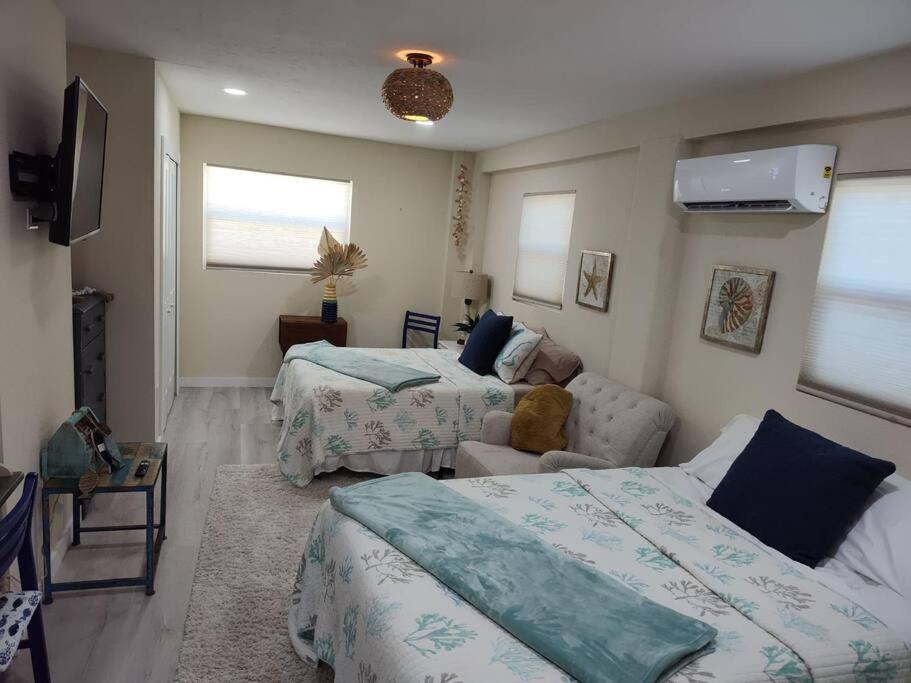 uma sala de estar com duas camas e um sofá em Completely Renovated! Half Duplex 1mile to Beach em Nokomis