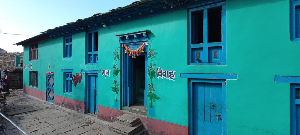 um edifício colorido com tinta azul e verde em Deep Jyoti Home stay em Bāgeshwar
