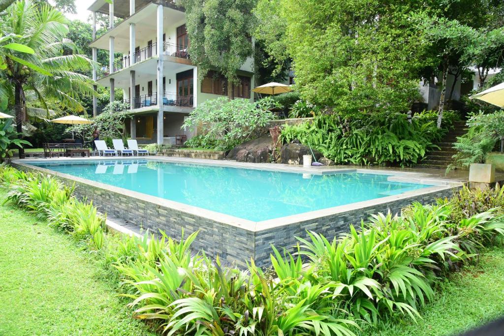 a swimming pool in front of a building at Hikka Secret Lake Resort in Hikkaduwa