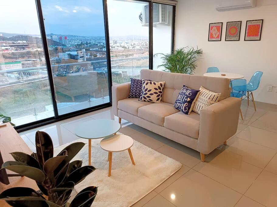uma sala de estar com um sofá e uma mesa em Departamento Linda Vista Privado A/C Cochera 24/7 em Querétaro