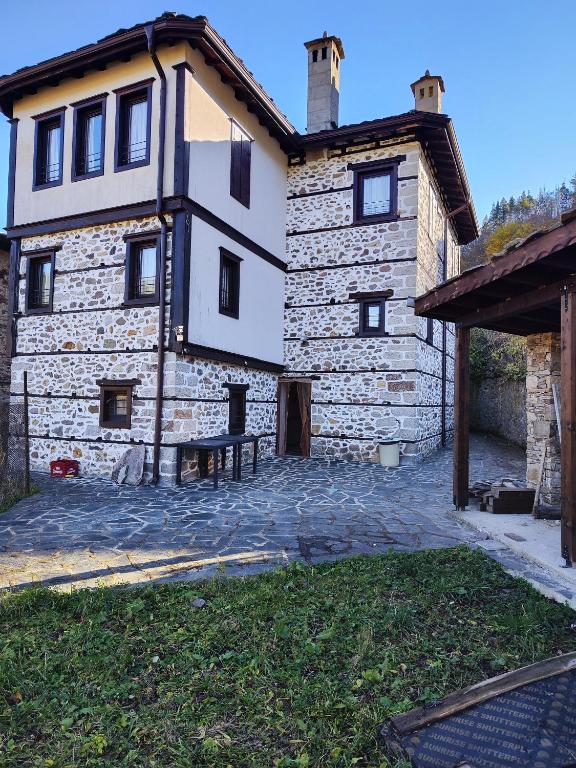 een stenen gebouw met een picknicktafel ervoor bij Сияние in Smolyan