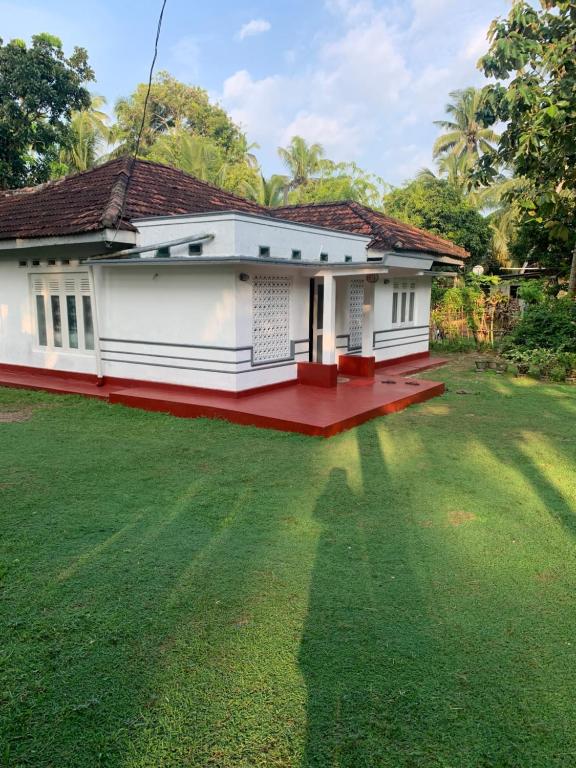 a house with a large lawn in front of it at Unrushed Midigama in Midigama East