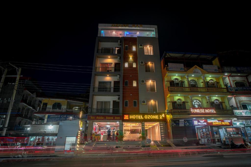 a tall building is lit up at night at Hotel Ozone 24 in Butwāl