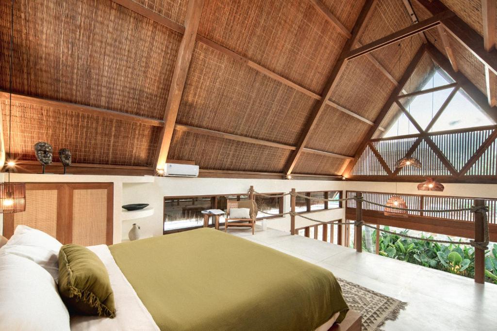 sypialnia z łóżkiem w pokoju z oknami w obiekcie Tias Villas w Kuta Lombok