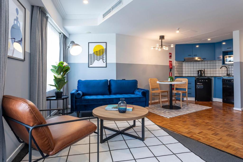 a living room with a blue couch and a table at Gia Sydney in Sydney