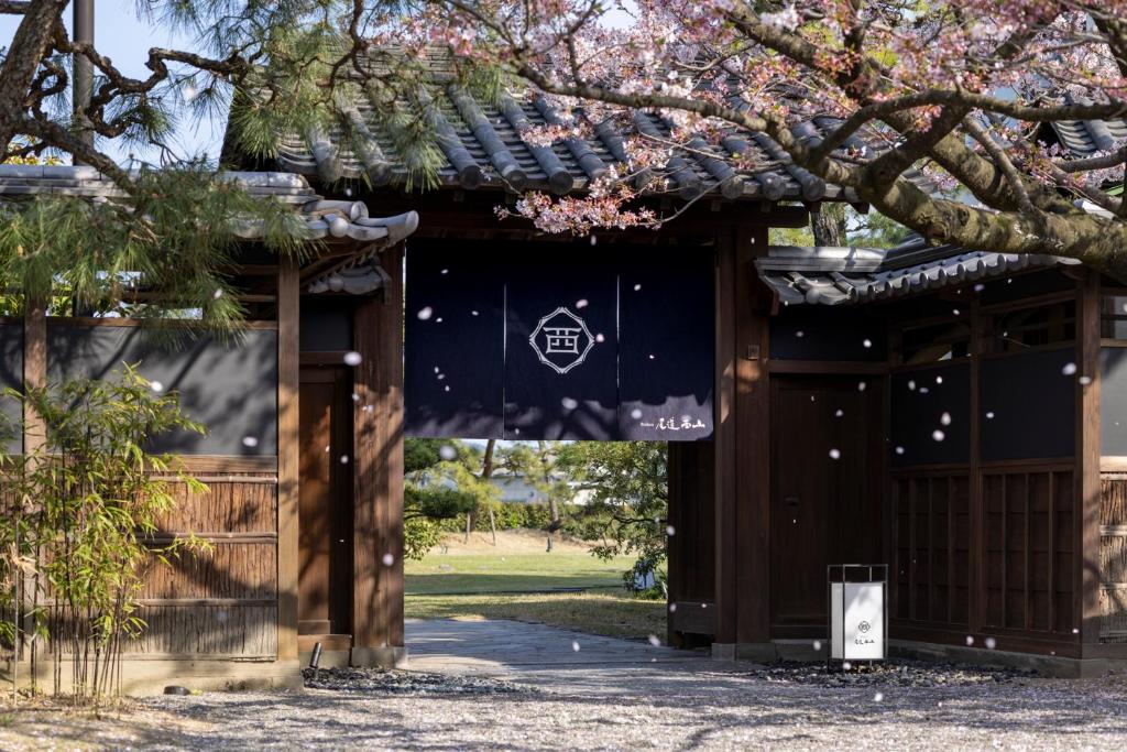 Ryokan Onomichi Nishiyama في أونوميتشي: بوابة إلى معبد في حديقة مع شجرة