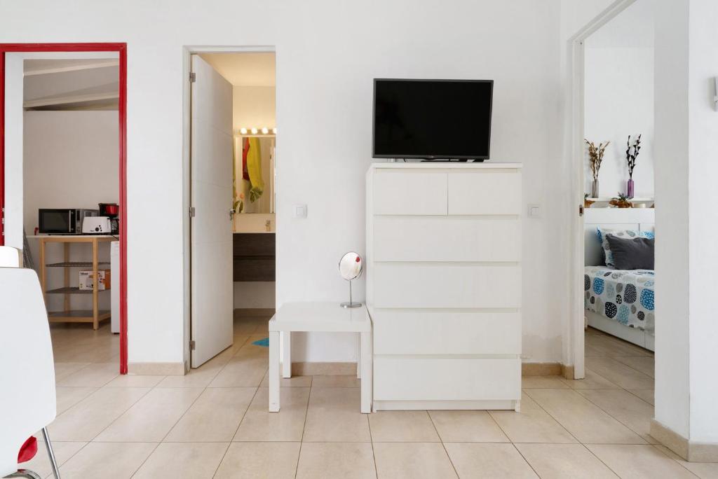 salon z telewizorem na białej ścianie w obiekcie Bungalow Aloe Dunas 2 w mieście Maspalomas