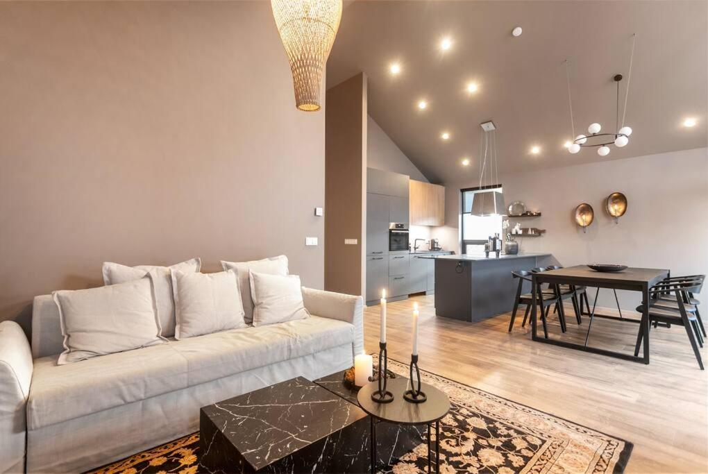 ein Wohnzimmer mit einem weißen Sofa und einem Tisch in der Unterkunft Luxury down town/Free parking in Reykjavík