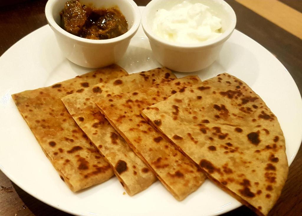 Un plato blanco con cuatro trozos de comida. en Hotel Braj Haveli, en Jaipur