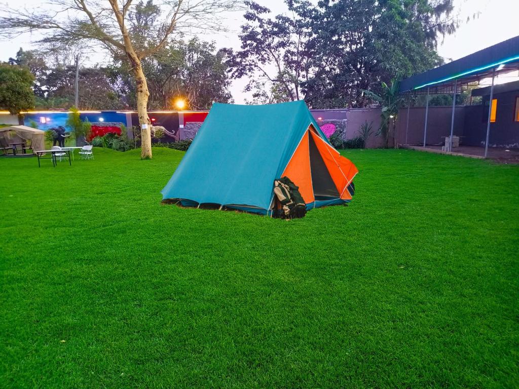 een blauwe en oranje tent op het gras bij Lush Garden Camping in Arusha