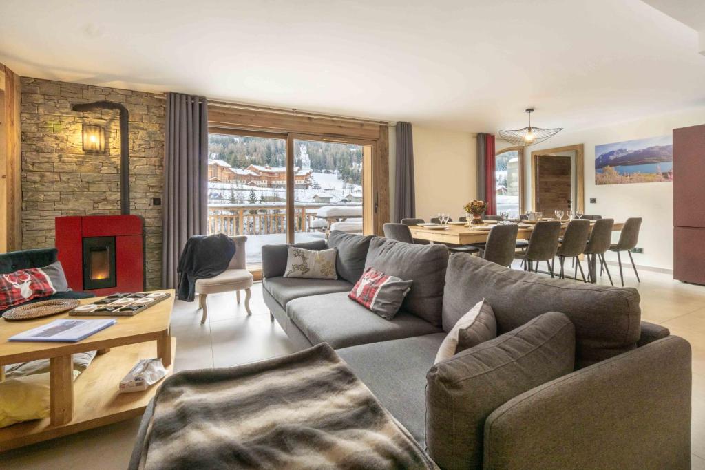 ein Wohnzimmer mit einem Sofa und einem Tisch in der Unterkunft Chalet La Turra, Spa privée in Lanslebourg-Mont-Cenis