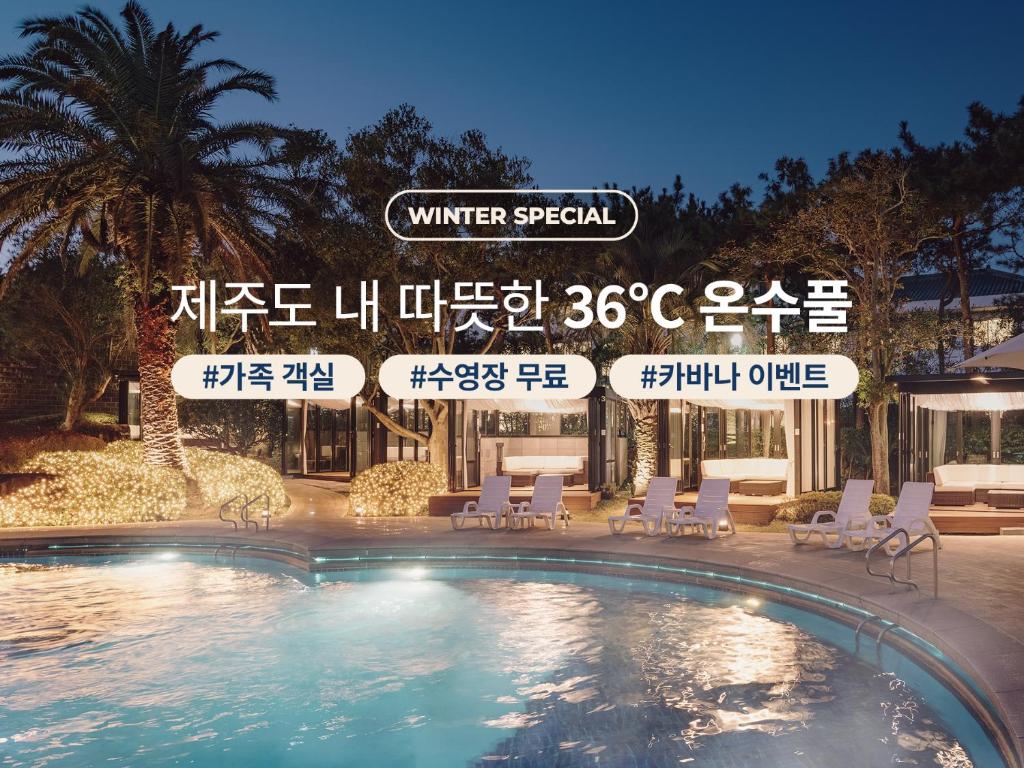 a swimming pool with chairs and a sign above it at The Suites Hotel Jeju in Seogwipo
