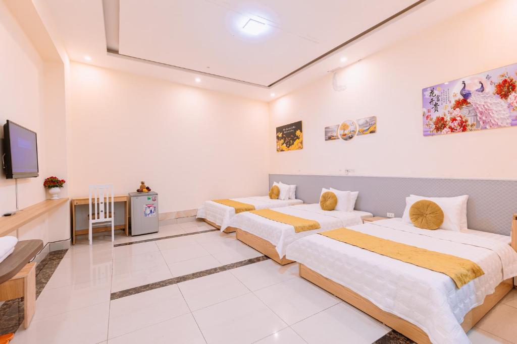 Habitación con 2 camas, TV y escritorio. en Golden Diamond Hotel en Hanói