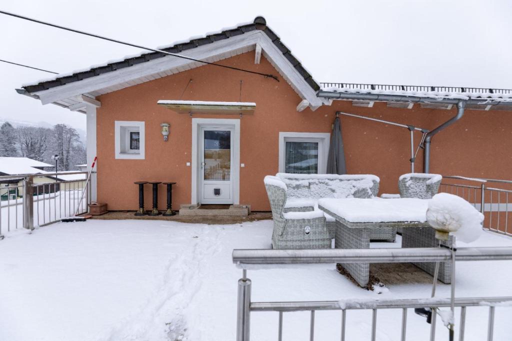 a house covered in snow with a table and chairs at Wohnung am Stadtrand in Salzburg