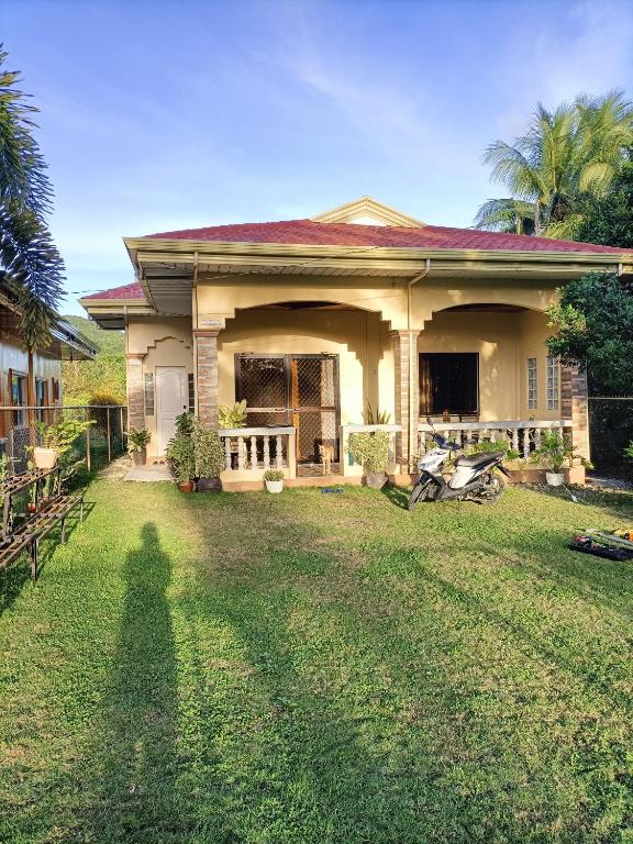 a shadow of a person standing in front of a house at Regina's Vacation House in Tayud