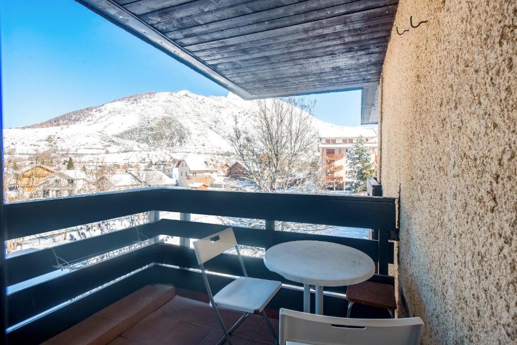 a balcony with a table and a view of a mountain at Piolit andCo - Studio vue montagne in Ancelle