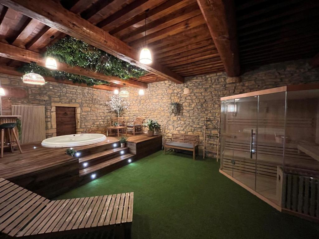 Großes Zimmer mit grünem Boden und Holzdecken. in der Unterkunft Le Clos Doré - appartement et Spa in Chessy