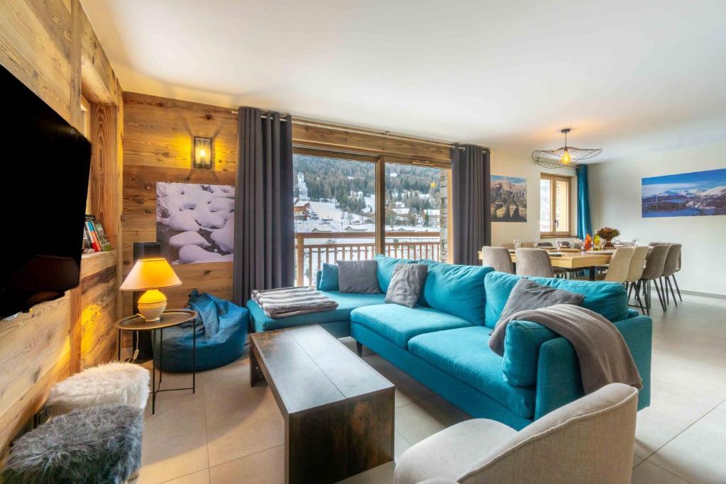 uma sala de estar com um sofá azul e uma mesa em Chalet L'arcelle, Spa privée em Lanslebourg-Mont-Cenis