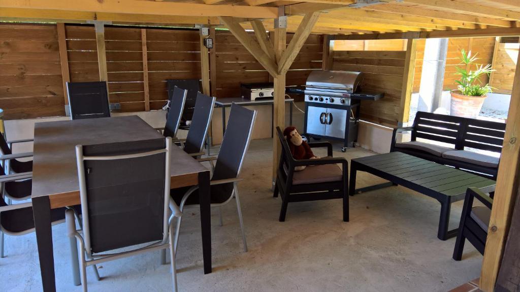 une salle à manger avec des tables, des chaises et une cuisinière dans l'établissement LA MAISON DU CAMINOL, à Monségur