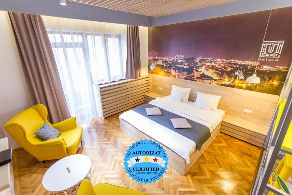 una stanza d'albergo con un letto e una sedia gialla di Corvin's Crib a Cluj-Napoca