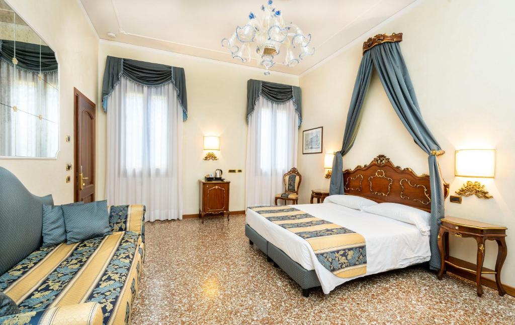 - une chambre avec un grand lit et un canapé dans l'établissement Hotel Torino, à Venise