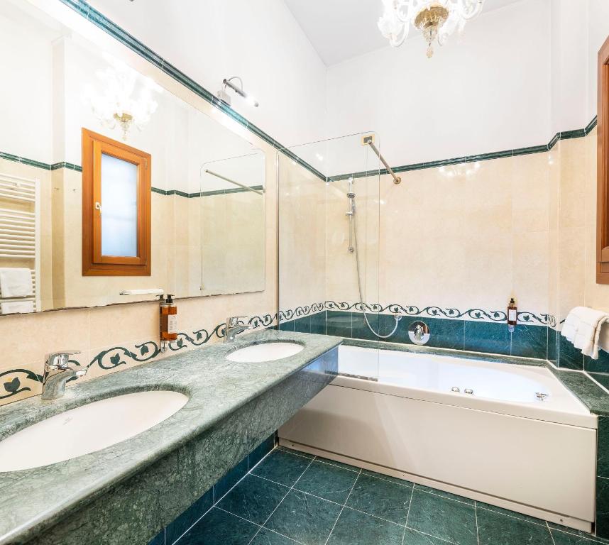 a bathroom with two sinks and a large mirror at Hotel Torino in Venice