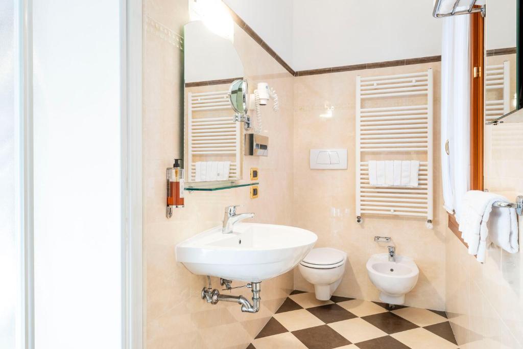 a bathroom with a sink and a toilet at Hotel Torino in Venice