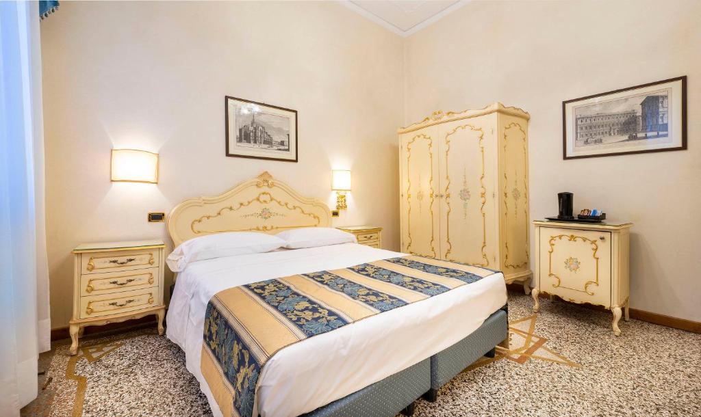 a bedroom with a large bed and two night stands at Hotel Torino in Venice