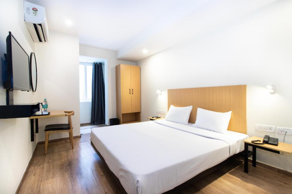 Ένα ή περισσότερα κρεβάτια σε δωμάτιο στο Sanctum Suites Richmond Road Bangalore