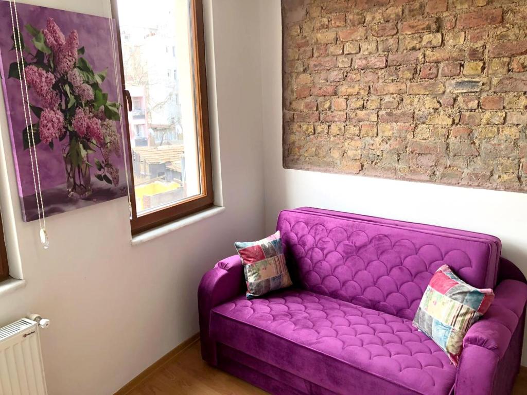 a purple couch in a room with a brick wall at Istanberry - Dream Apartments in Istanbul