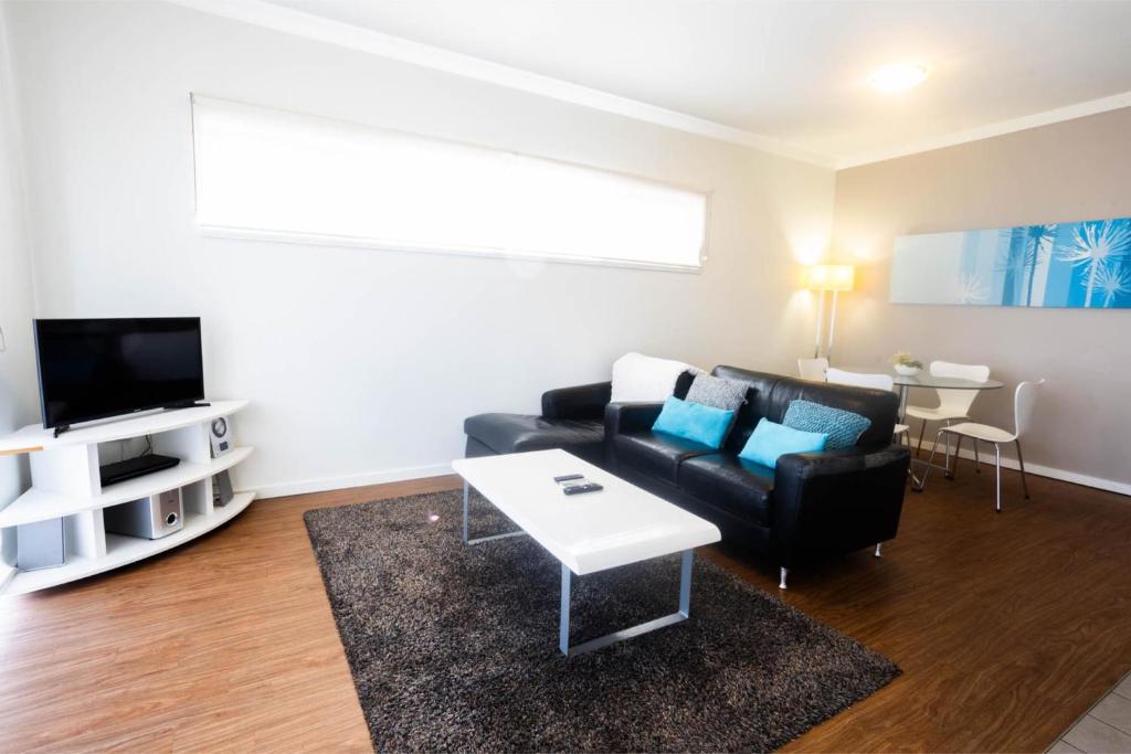 a living room with a couch and a table at Lovely 2BR Apartment in West Perth with Parking! in Perth