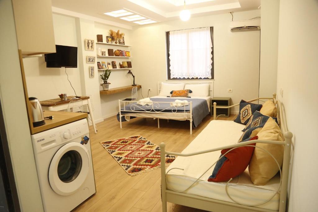 a living room with a bed and a washing machine at Illyrian studio apartment 2 in Tirana
