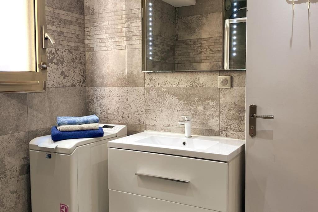 une salle de bain avec un lavabo blanc et un miroir dans l'établissement St Raphaël centre calme clim mer commerces à pieds, à Saint-Raphaël