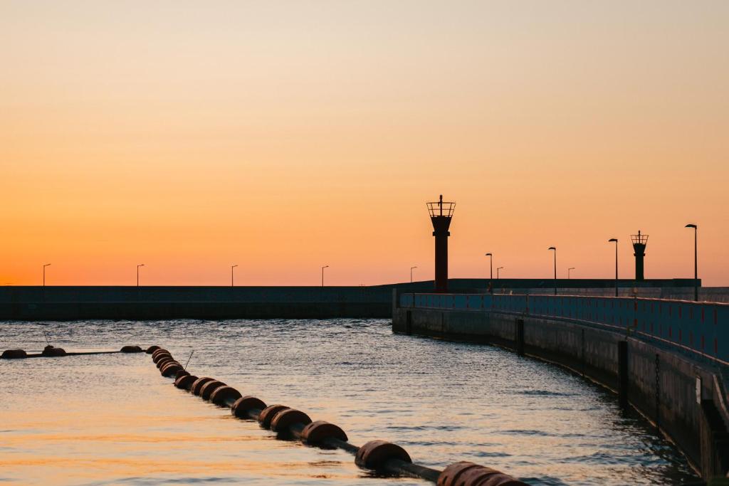 une masse d'eau avec une jetée et un pont dans l'établissement Meduza ośrodek wczasowy, à Mrzeżyno