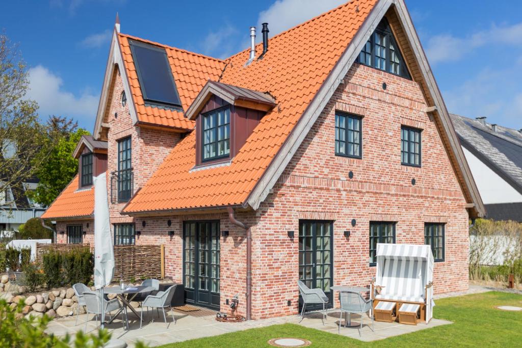 an exterior view of a house with an orange roof at Lille Wung in Wenningstedt