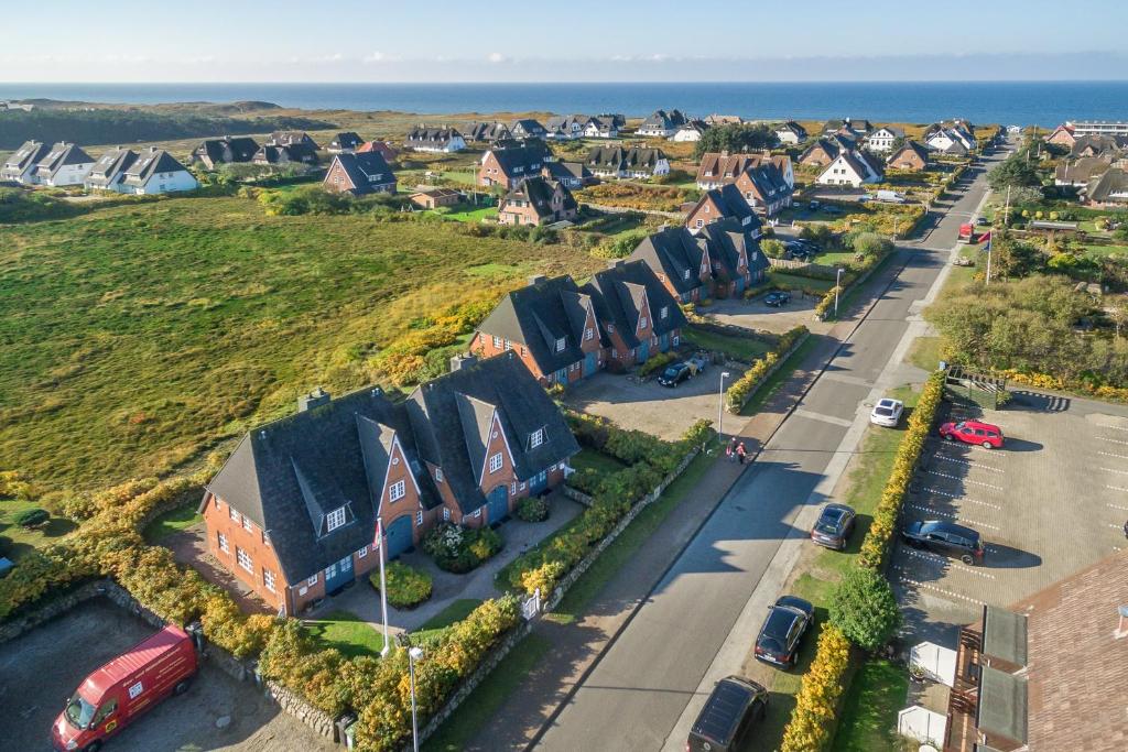 een luchtzicht op een woonwijk met huizen en de oceaan bij Heidepark in Wenningstedt