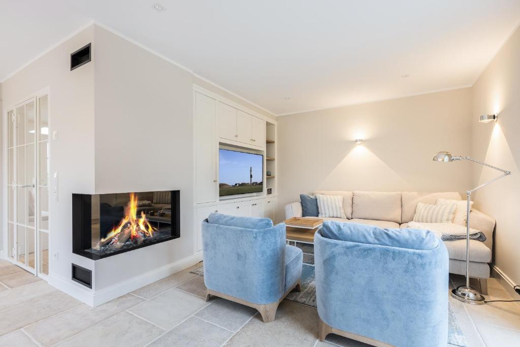 a living room with a couch and a fireplace at Beachmemories in Wenningstedt