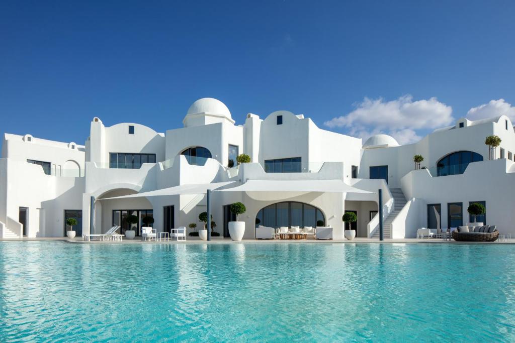 um grande edifício branco com uma piscina em frente em Anantara Santorini Abu Dhabi Retreat-Adults Only em Al Rahba