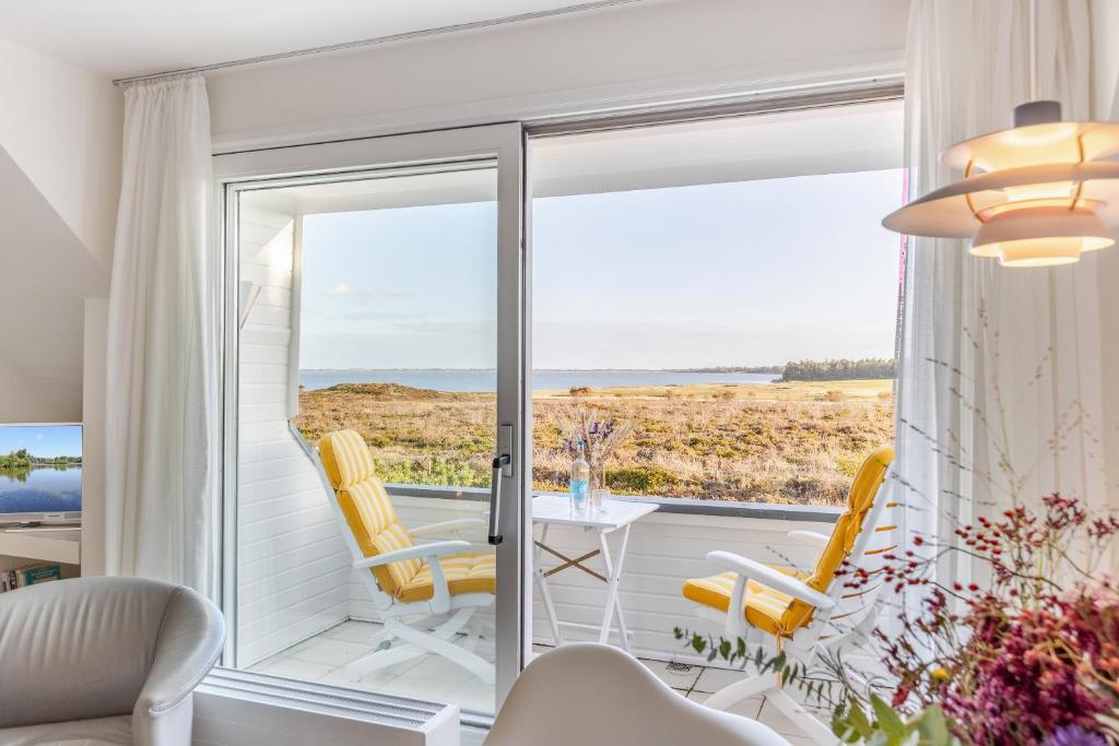 a living room with a sliding glass door with a table and chairs at Wattblick in Munkmarsch