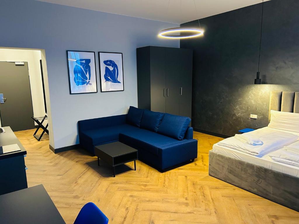 a bedroom with a blue couch and a bed at Motel Blue Messe in Berlin