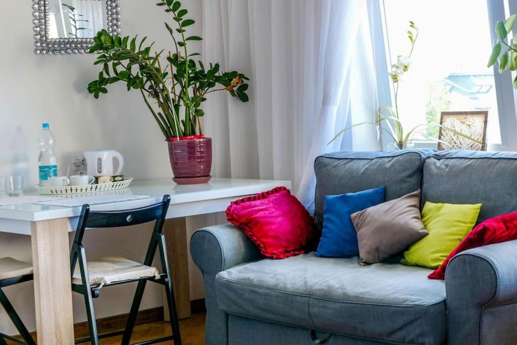 uma sala de estar com um sofá azul com almofadas coloridas em A cosy private room in the heart of old Podgorze em Cracóvia