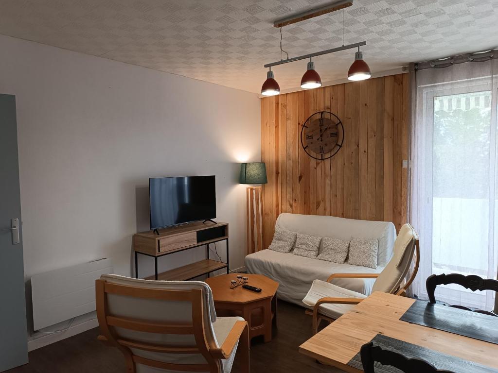 un salon avec un canapé blanc et une télévision dans l'établissement Appartement cosy en résidence, avec parking, à Saint-Hilaire-de-Riez